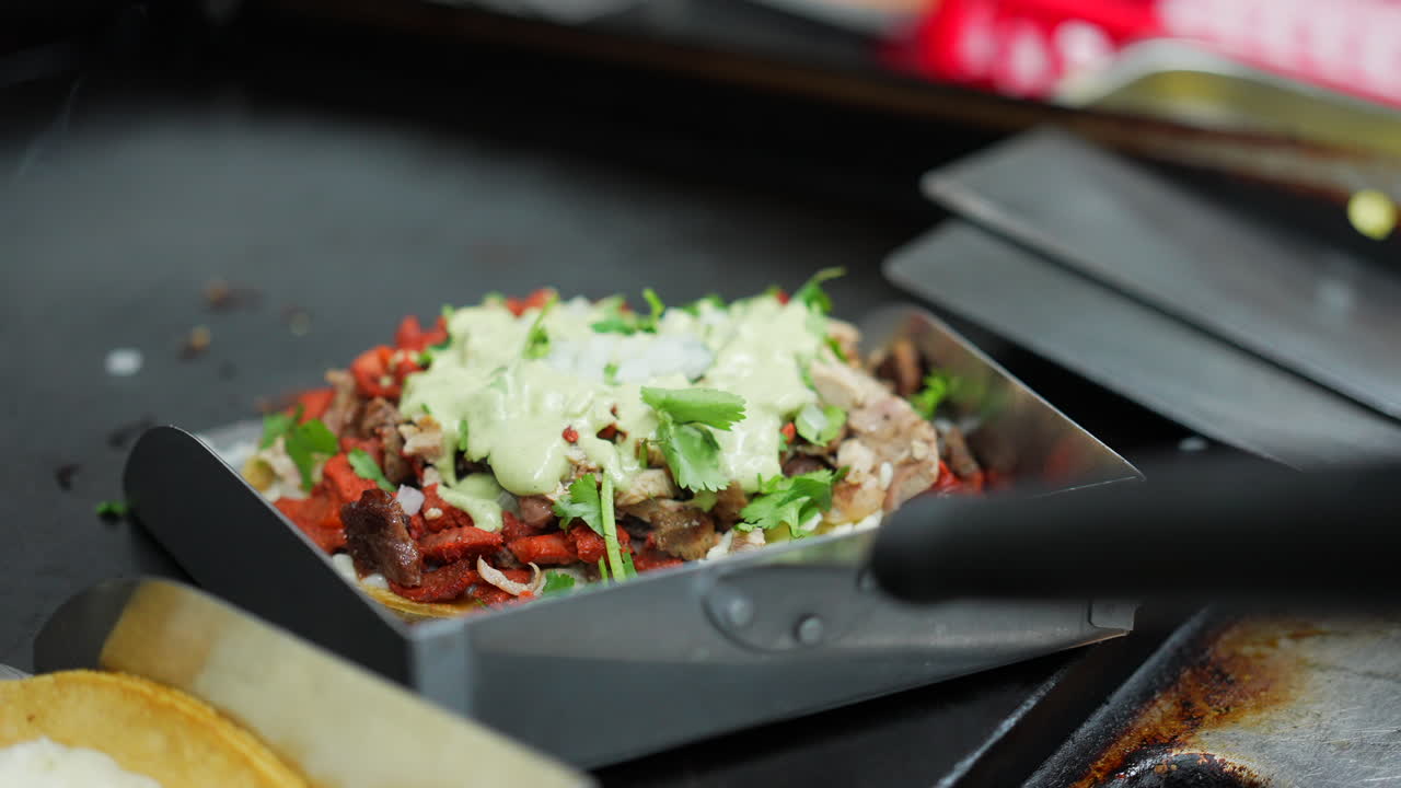 agregando salsa de aguacate al fondo de una mulita - serie de camiones de comida