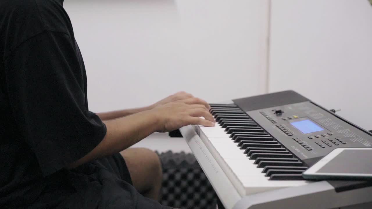 fotografía en primer plano de un pianista tocando el piano en un estudio de grabación