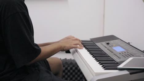 close-up shot of a pianist playing music on the piano in a recording studio