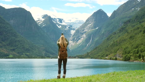 woman taking photo of norwegian fjord landscape