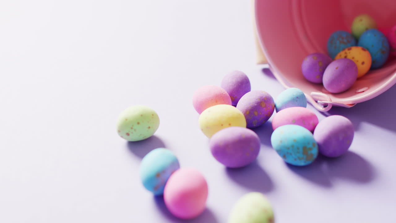 Balde com ovos de Páscoa coloridos em fundo roxo com espaço para texto.