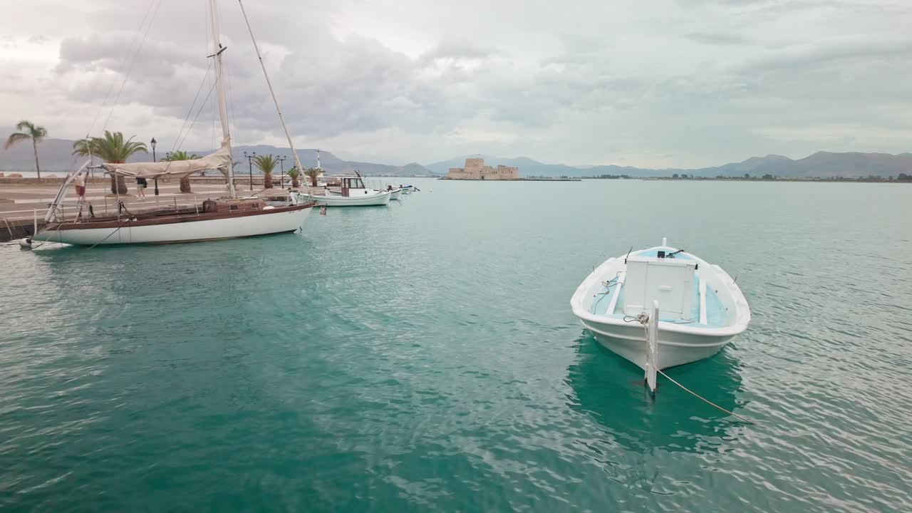 Greek Boats in peaceful rippled azure sea, scenic Bouritz bay castle