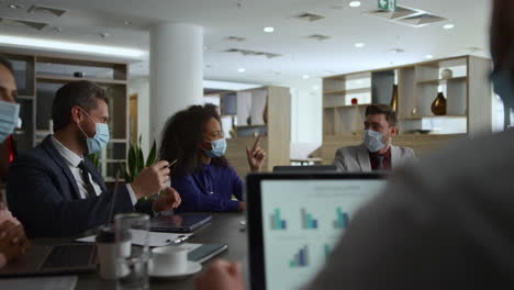multiethnic office workers discuss financial plan. business group in facial mask