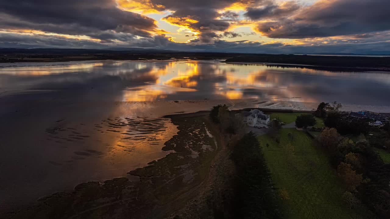 tiro de hiperlapso sobre una mansión de lujo frente al lago con un reflejo vibrante de la puesta de sol