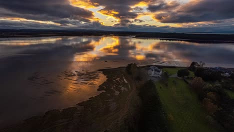 hyperlapse shot over a lakefront luxury mansion with a vibrant sunset reflecting