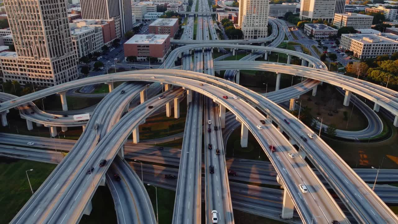 Aerial view of busy highway interchange with flowing traffic, showcasing intricate road patterns and urban landscape, capturing dynamic movement and connectivity