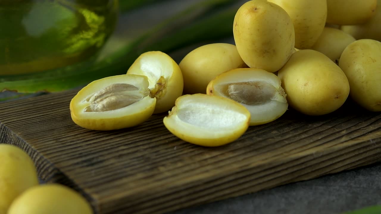 las palmeras de dátiles frescas se colocan en la mesa con aceite, concepto de alimentos saludables. palmeras de dátils. frutas crudas de palmieras de dátiles (phoenix dactylifera)