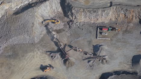 quarry with excavators, conveyor belts, and trucks processing and transporting aggregates in county meath, ireland. aerial topdown shot
