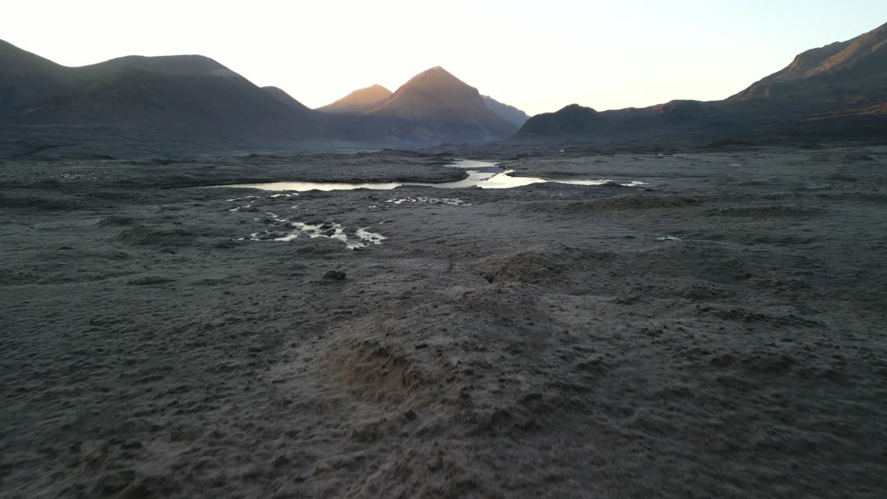 excursionista volando hacia la luz del amanecer atravesando montañas distantes en la isla del cielo escocia