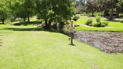 una mujer corre en el parque mientras corre más allá de la cámara