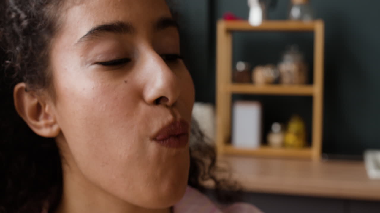 Close-up of a person enjoying a slice of cheesy pizza