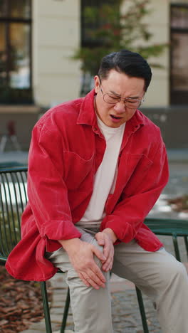 asian mature man suffer from painful severe knee joint ache, leg muscles illness cramps rheumatism