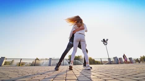 dancing together outdoor. young couple dancing against the background of fountain