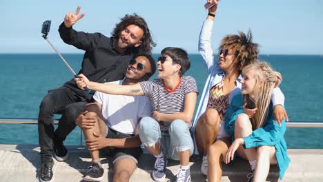 Laughing-friends-taking-selfie-on-seafront-