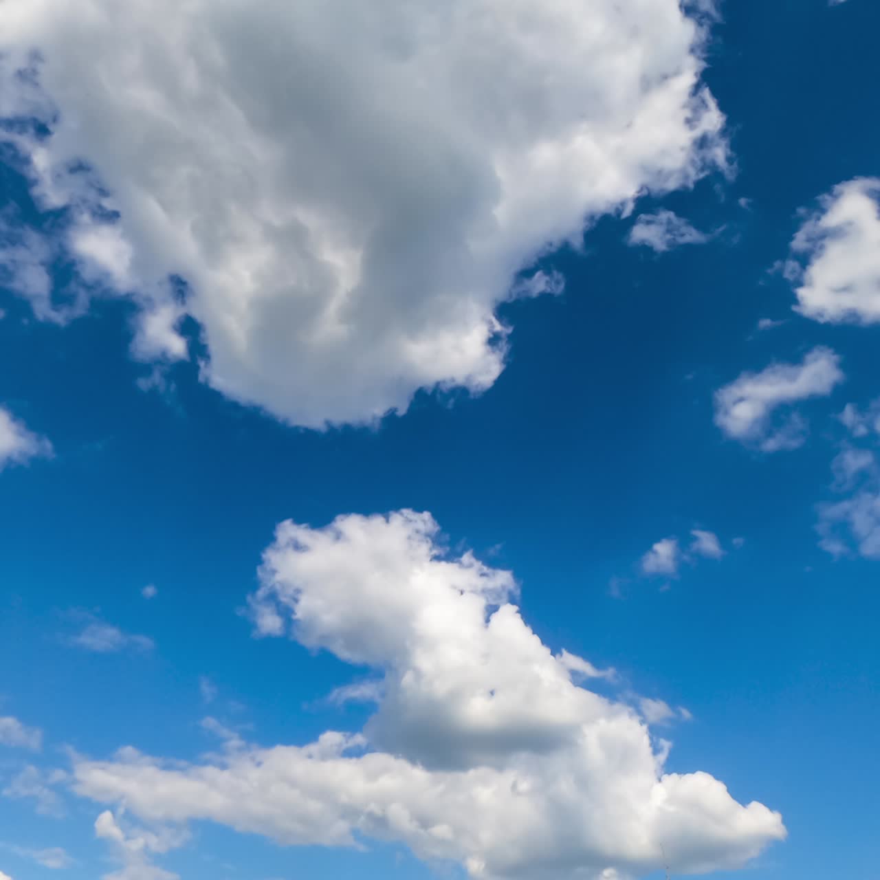 Amazing bright blue sky with little clouds flying through. Beautiful timelapse of fluffy clouds transformation