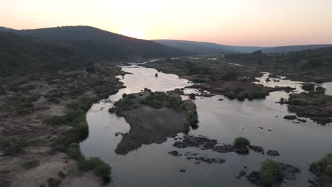 drone descends or dips low over the seasonal komati river, revealing the vastness of the bushveld