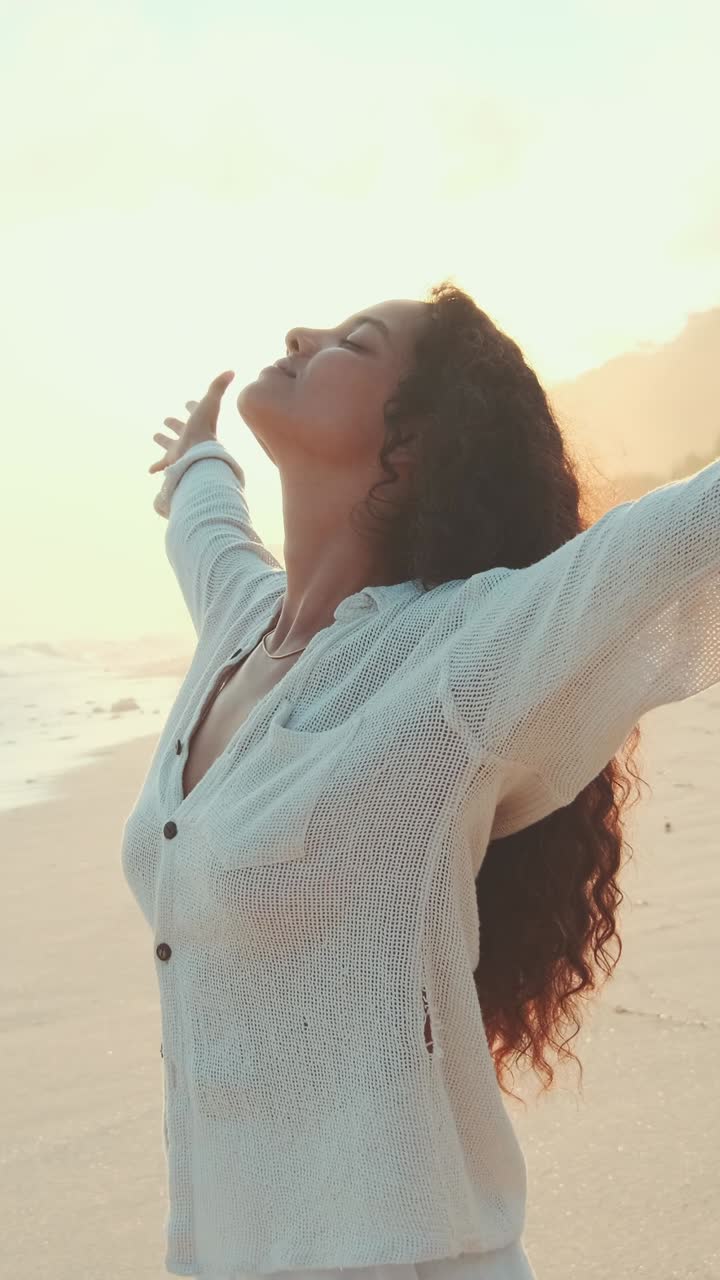 Young attractive tanned indian woman traveler stands on evening beach
