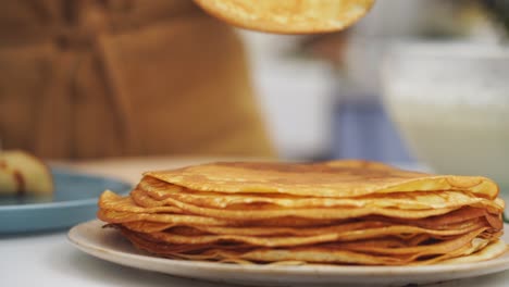 Cocinero-Anónimo-Tomando-Un-Panqueque-De-Un-Plato-Con-Varios-Panqueques