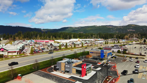 Cars-Driving-In-The-Road-Passing-By-Fast-Food-Restaurant-Chain-In-Port-Alberni,-BC,-Canada