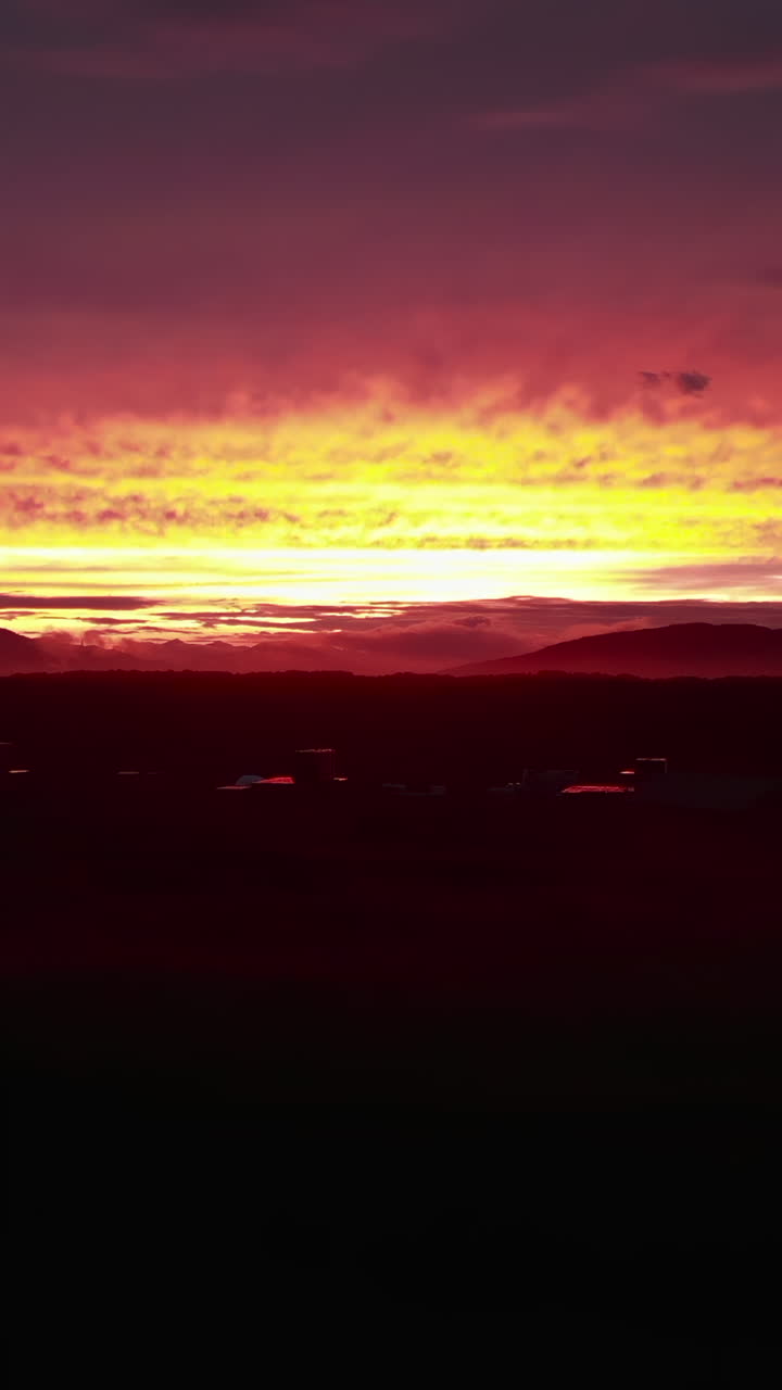 Dramatischer roter und gelber Sonnenuntergang über Bergen im Gegenlicht