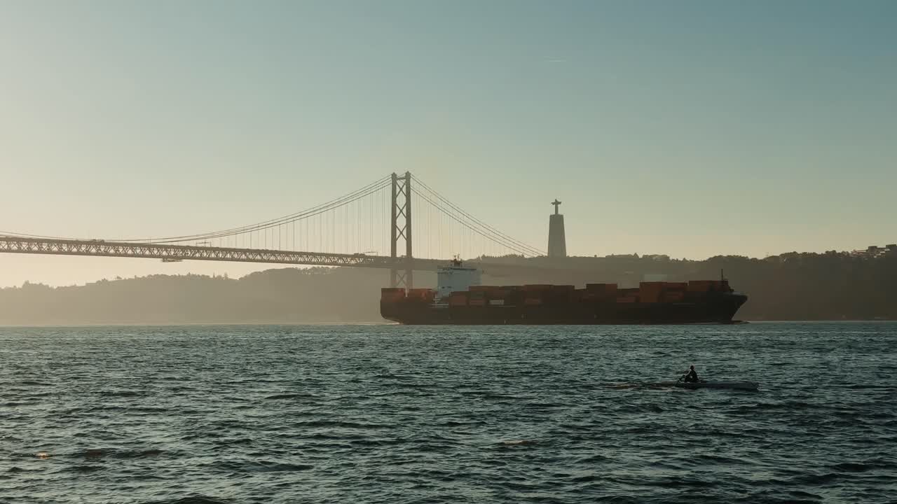 Lisbon cityscape with 25 de Abril Bridge, Cristo Rei statue, and cargo ship
