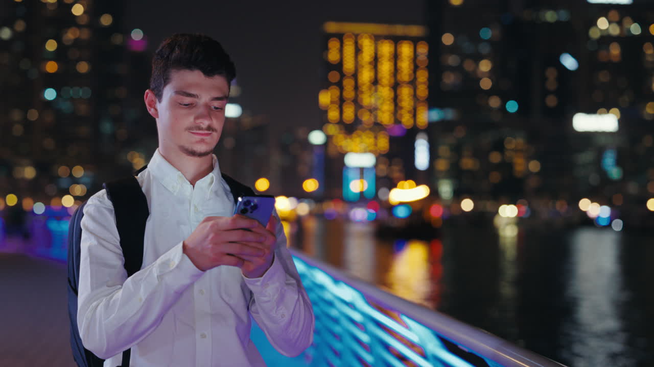 Man using smartphone at night in the city