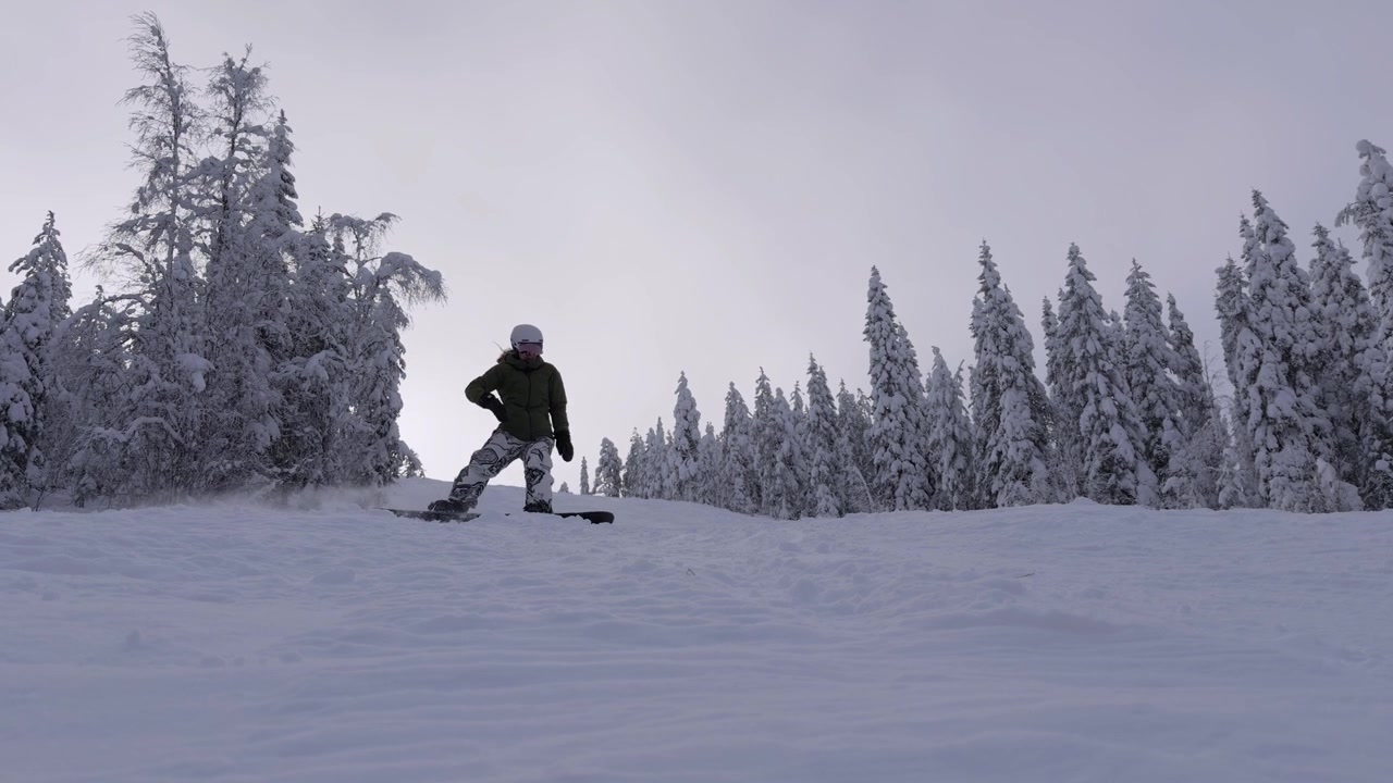 Snowboarder irriconoscibile che fa snowboard su una pista da sci vuota. STATICO