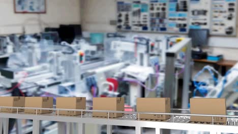 Multiple-delivery-boxes-on-conveyor-belt-against-office-in-background