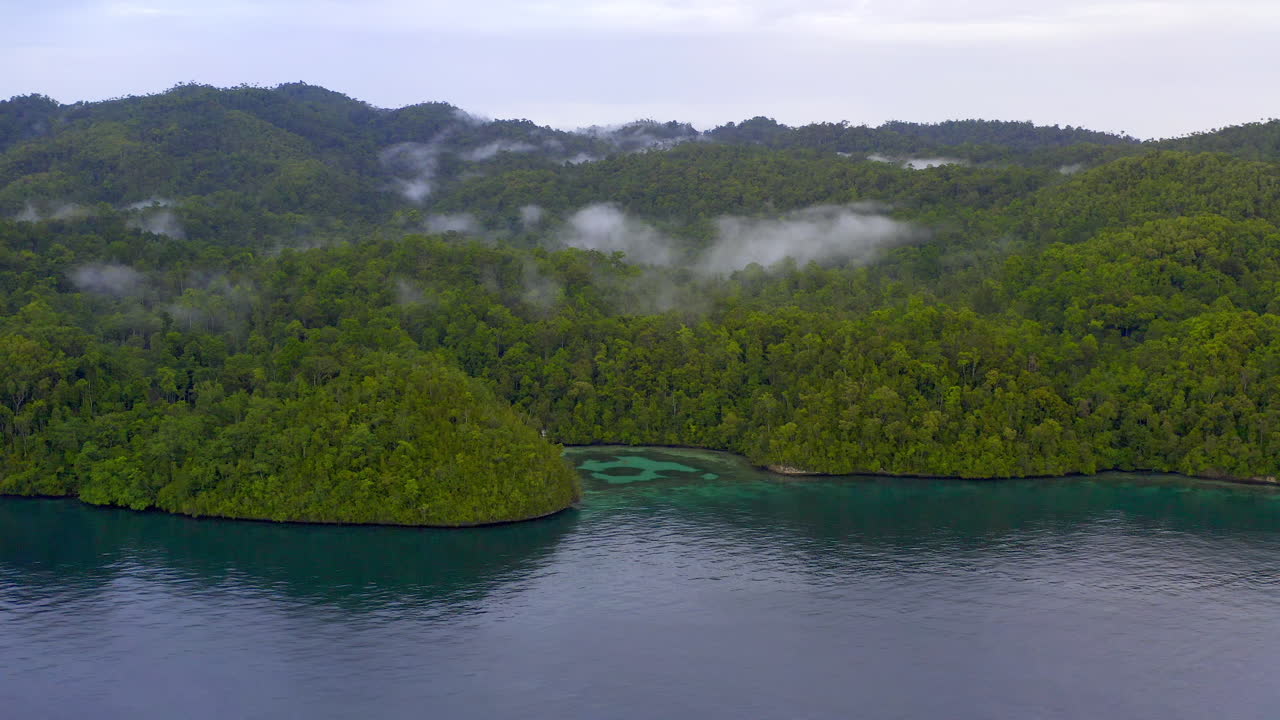 bahía de una isla tropical con montañas de niebla.