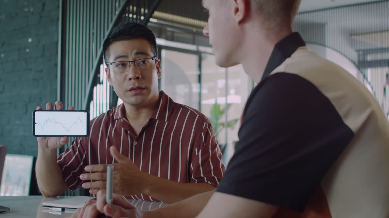 Trader Teaching Young Businessman How to Analyze Financial Charts