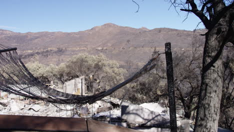 panning shot of burned hammock in front of burned home in malibu, california