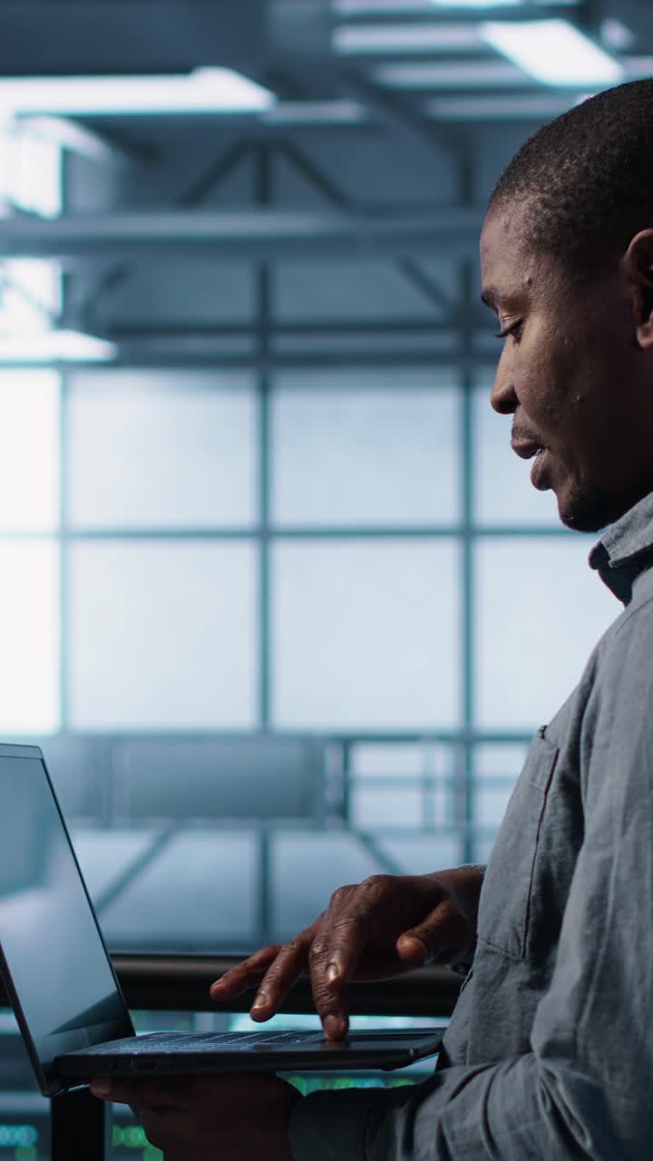 Vertical video Smiling admins using laptop in data center, managing server virtualization
