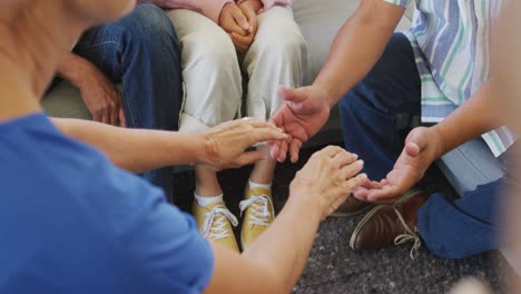 Senior-diverse-people-at-meeting-holding-hands-at-retirement-home