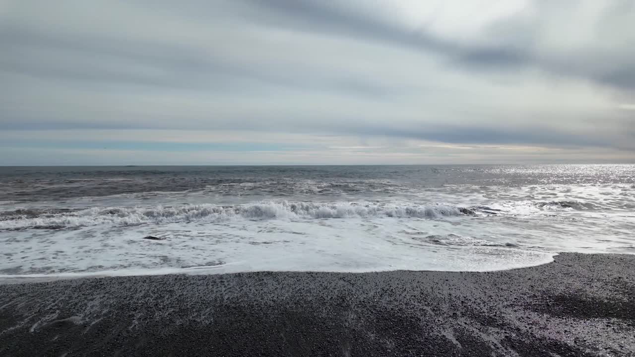 구름의 캔버스가 하늘을 가로질러 펼쳐져 있고, 그 에서 느린 파도가 진정시키는 부드러움으로 굴러와 평온한 조화의 느낌을 불러일으킨다.
