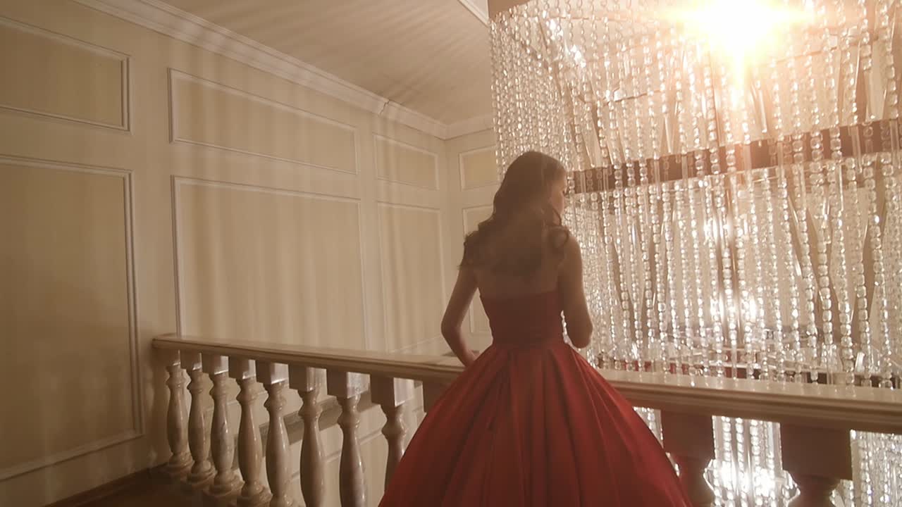 Elegant Woman in Red Dress on a Balcony