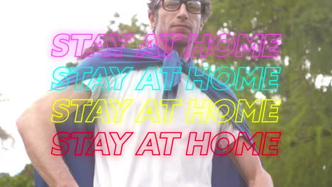 animation of four lines of neon text stay at home over caucasian man wearing a cape