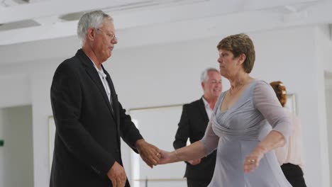 Caucasian senior couples spending time together dancing in a ballroom