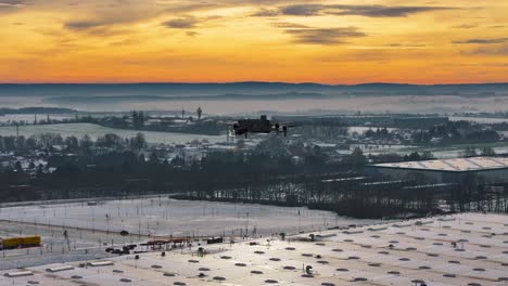 drone silhouette flying over misty winter landscape at golden sunset, czechia