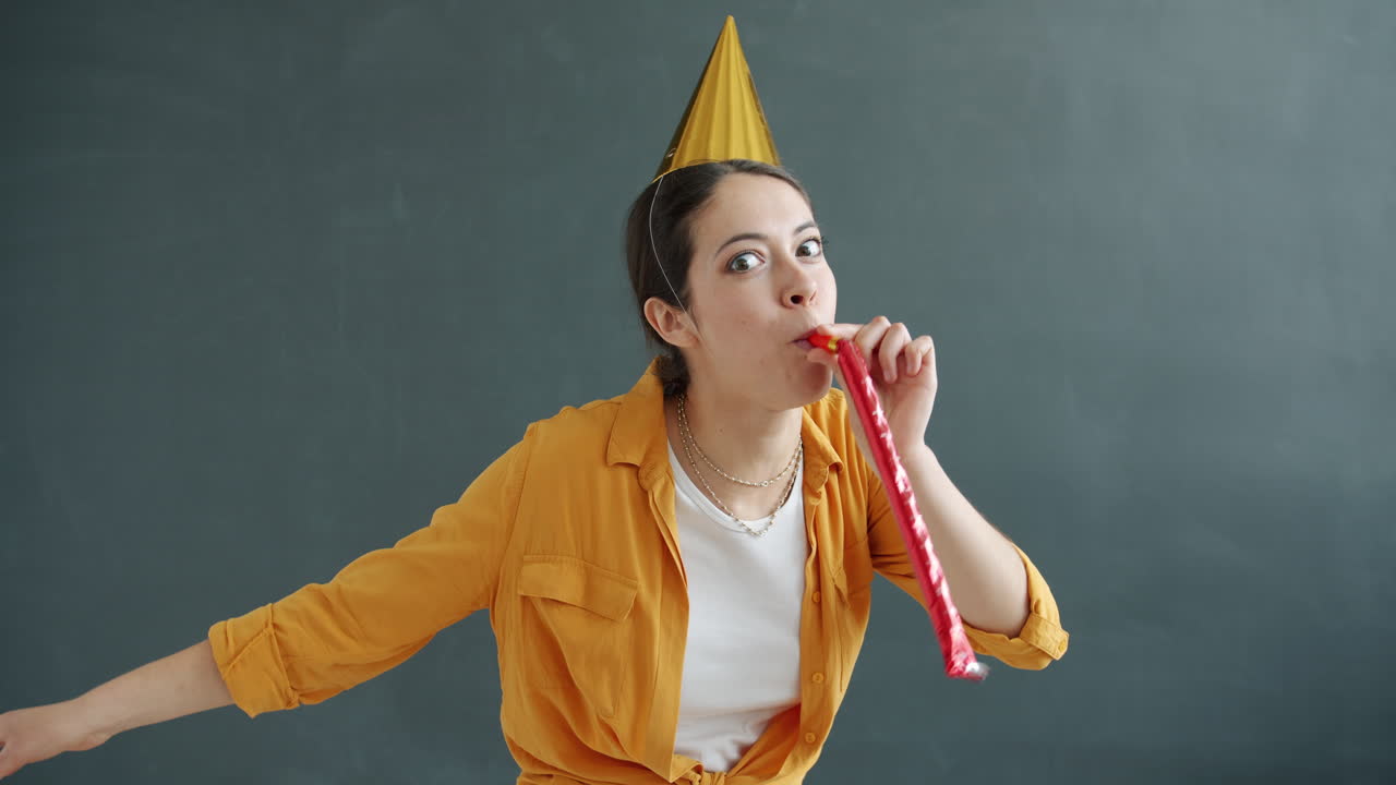 Woman celebrating with party hat and horn