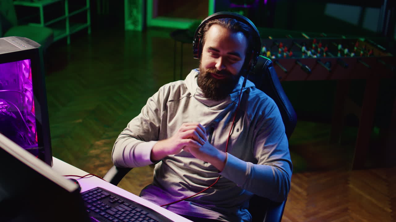 콘텐츠 제작자가 강렬한 게임 세션 후 헤드폰을 제거하고 관객과 채팅하고 있습니다.