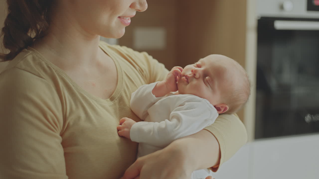 madre sosteniendo a un bebé dormido