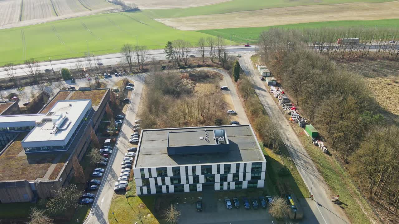 Drone flying towards an office building in rural Belgium on a sunny autumn day