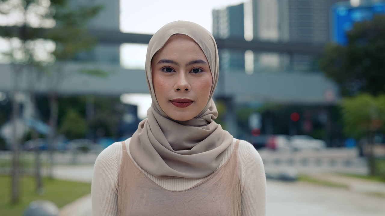 Woman in Hijab Making Call Me Sign in Urban Setting