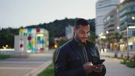 joven usando el teléfono inteligente al aire libre.