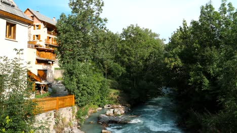 Casas-De-Pueblo-En-Los-Alpes-Al-Borde-De-Un-Torrente