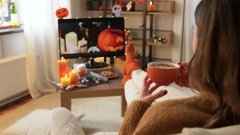 woman relaxing on the couch watching a halloween movie