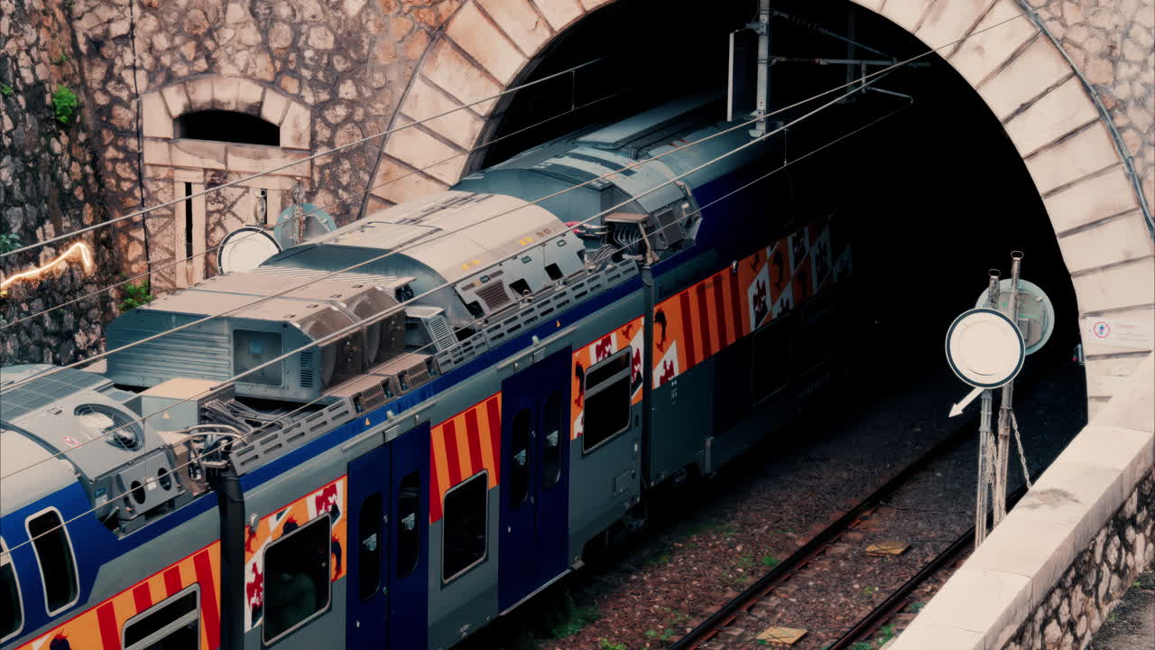 Train going through a tunnel near a beach in Villefranche sur Mer, France