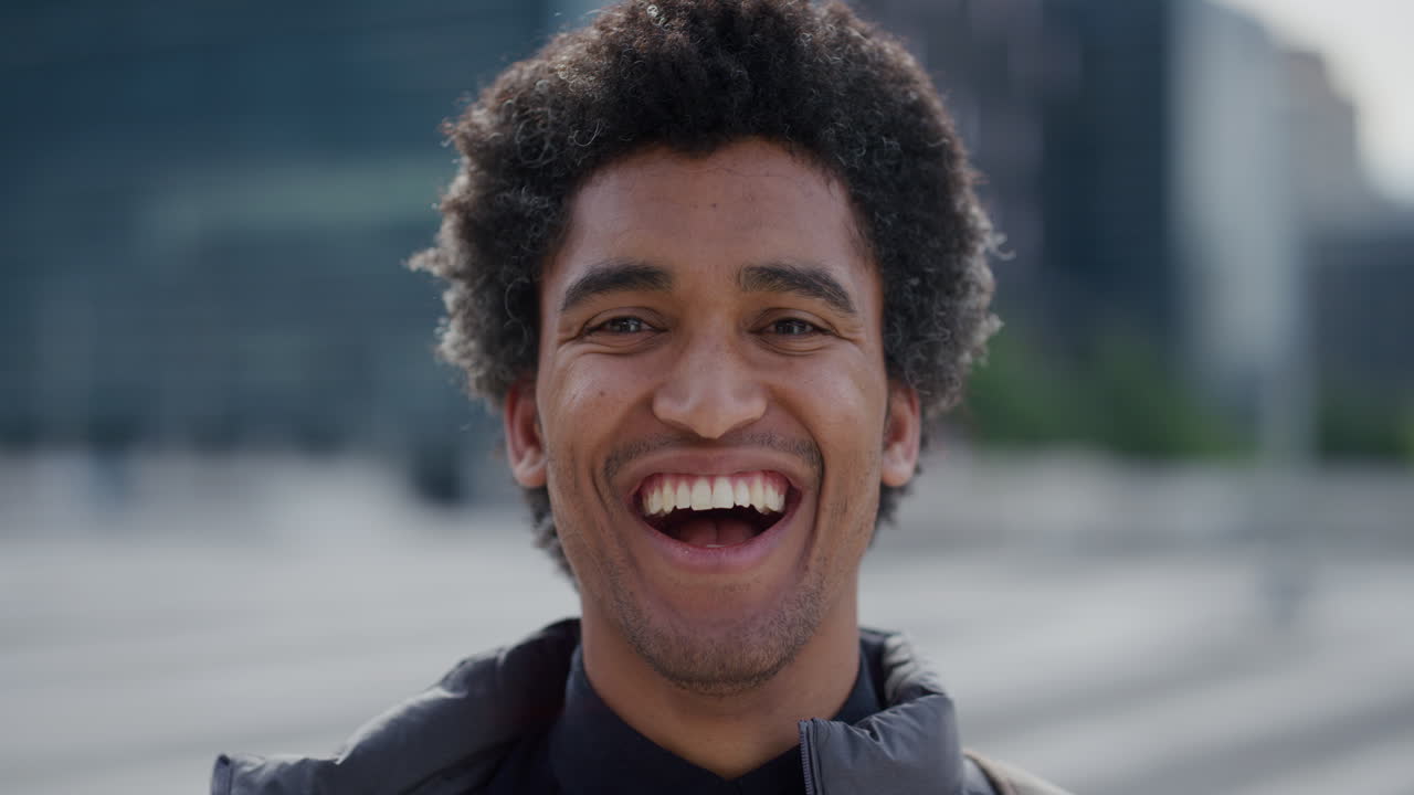 portrait successful young mixed race business man laughing enjoying professional urban lifestyle in city cheerful male afro hairstyle slow motion