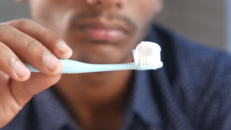 hombre con un cepillo de dientes con pasta de dientes