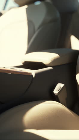 close-up of a luxury car interior with beige leather seats and a wooden center console.